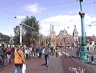 Амстердам. Улица Дамрак. Видна велосипедная дорожка. На заднем плане - фасад ж/д вокзала