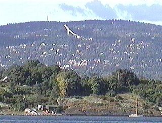 Вид на Осло из Осло-фьорда. Вдалеке виден трамплин Холменколлена